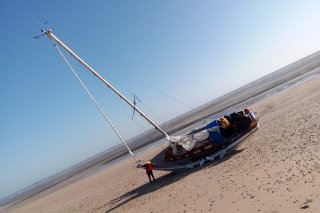 Pendant la nuit, le vent et les vagues ont fait céder l’ancre, le voilier n’est plus qu’à une vingtaine de mètres du rivage.